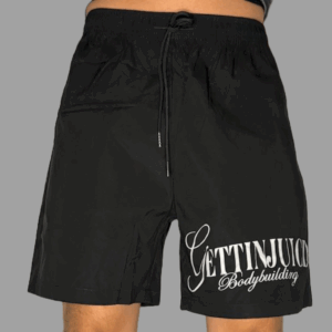 Model wearing GettinJuicd athletic gym shorts — mid-waist workout shorts for men with logo print and adjustable drawstring.