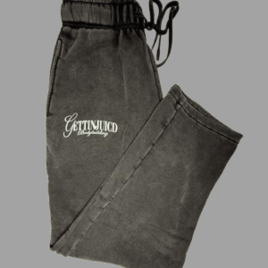 Flat lay of black GettinJuicd joggers with front logo and elastic waistband, folded for display.