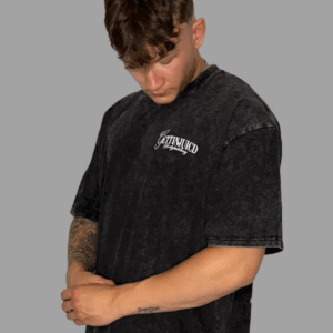 Front view of model wearing athletic fit t-shirt by GettinJuicd in faded black cotton with chest logo.