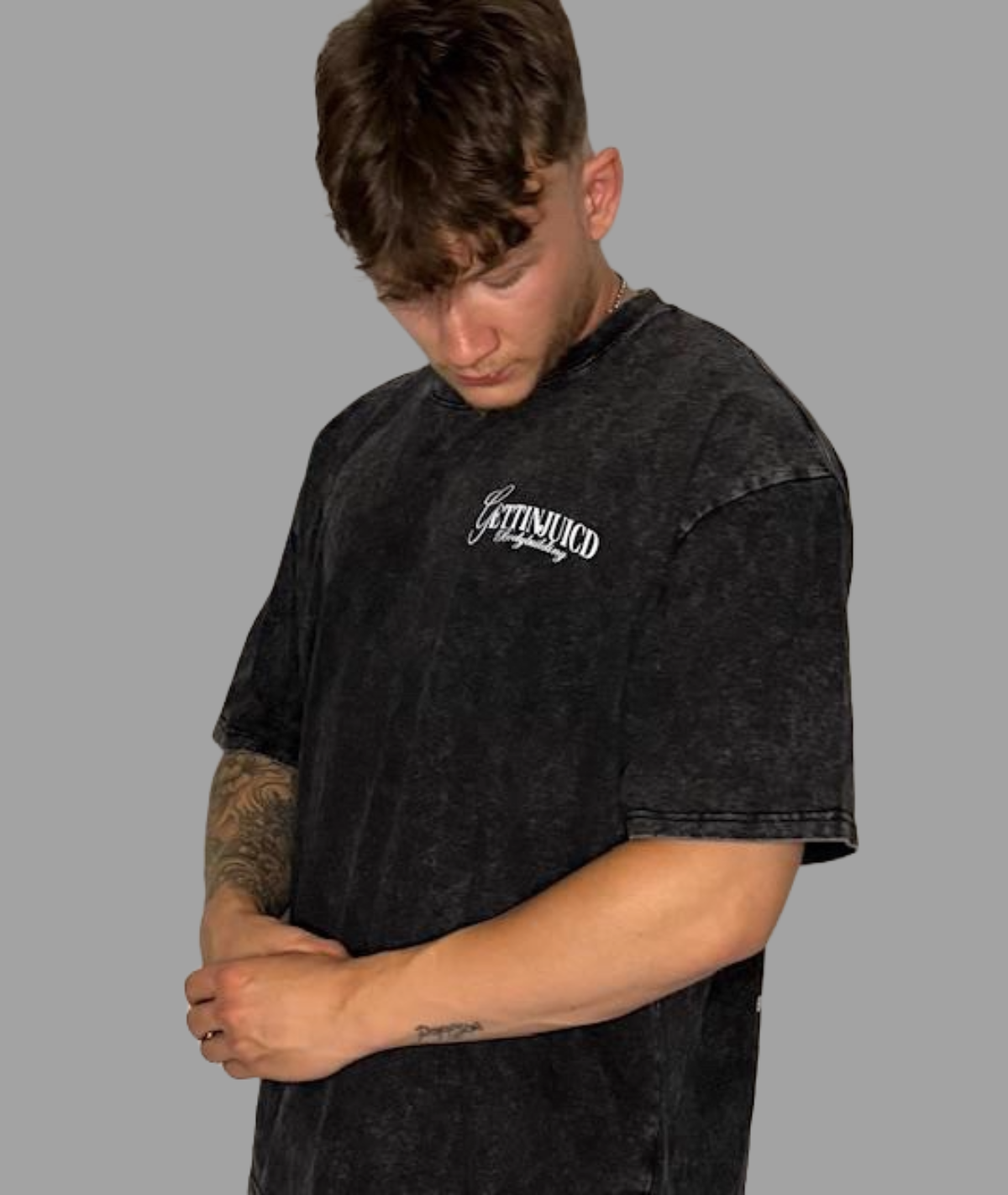 Front view of model wearing athletic fit t-shirt by GettinJuicd in faded black cotton with chest logo.