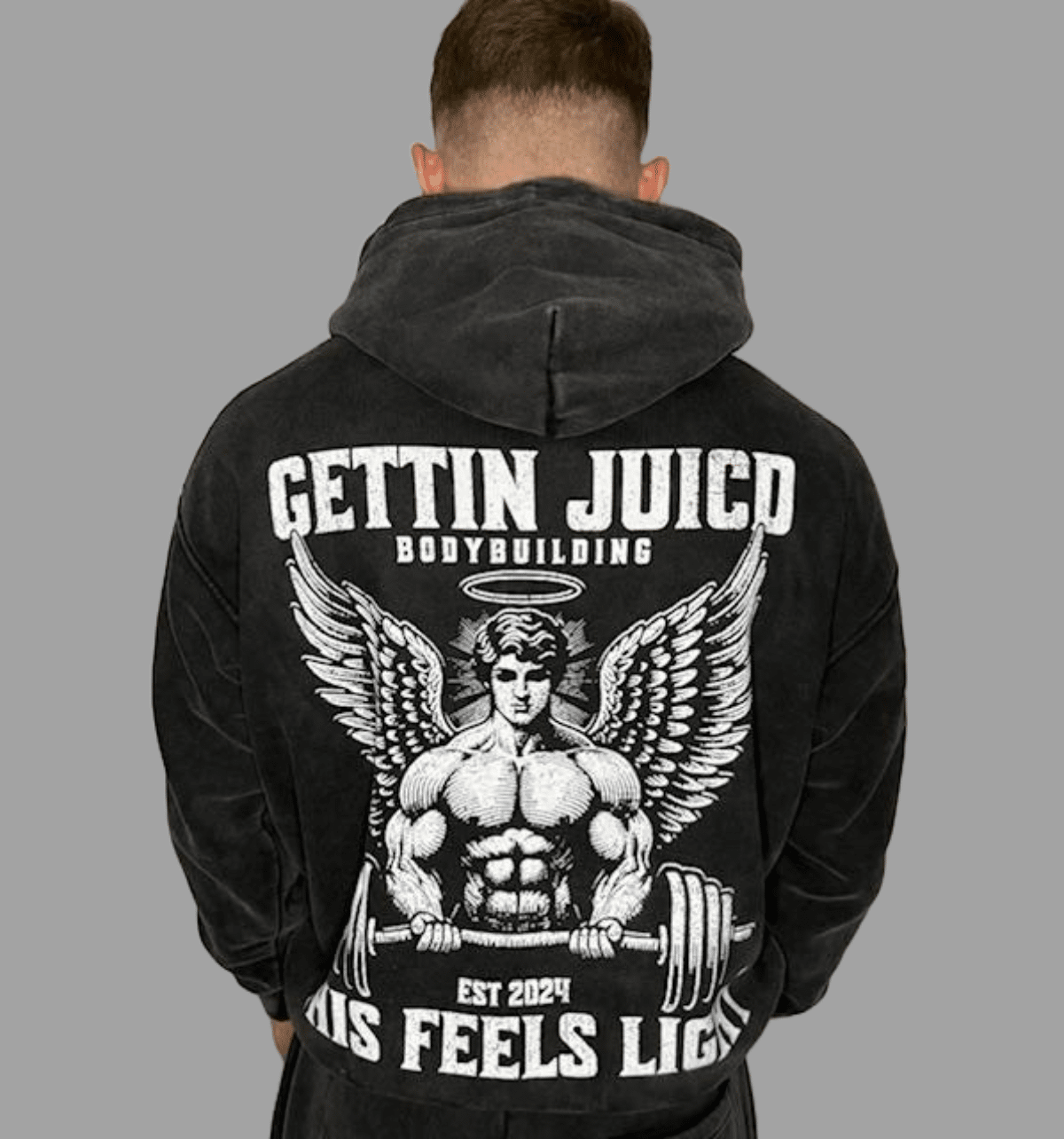 Model wearing Angels Strength men’s gym hoodie with winged bodybuilder graphic and ‘This Feels Light’ slogan.