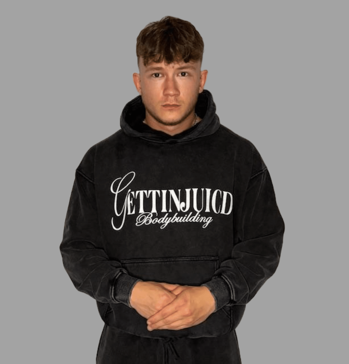 Front view of model wearing GettinJuicd athletic fit hoodie in acid-wash grey with front logo.